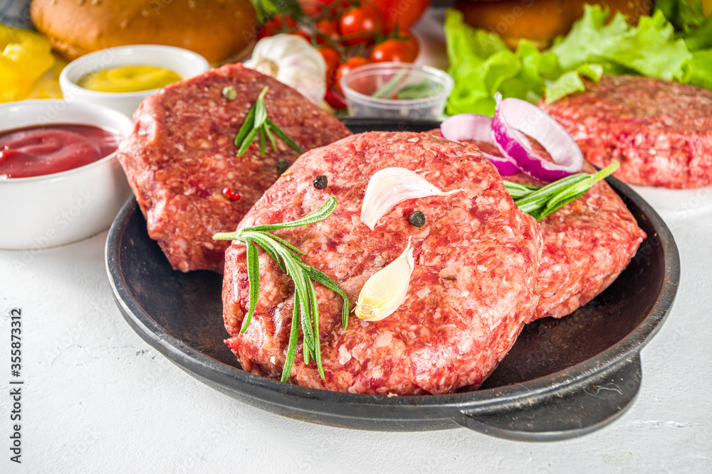 Cooking burger background. Set various cheeseburger and beefburger ingredients - bun, tomatoes, onion, lettuce, sauces, cheese and raw burger cutlets, ready for barbecue grill. Burger bbq party fest Cooking burger background. Set various cheeseburger and beefburger ingredients - bun, tomatoes, onion, lettuce, sauces, cheese and raw burger cutlets, ready for barbecue grill. Burger bbq party fest
