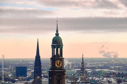 Scenic panorama view from Dancing Towers over Hamburg under snow on a misty day in winter with St. Michael's Church (German: St. Michaelis), Speicherstad and city skyline at sunset.