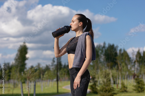 girl after jogging drinks water and pauses