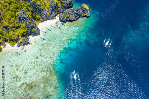 Shimizu Island  El Nido  Palawan  Philippines. Aerial drone view of a tiny tropical island with beach  coral reef and sharp limestone cliffs