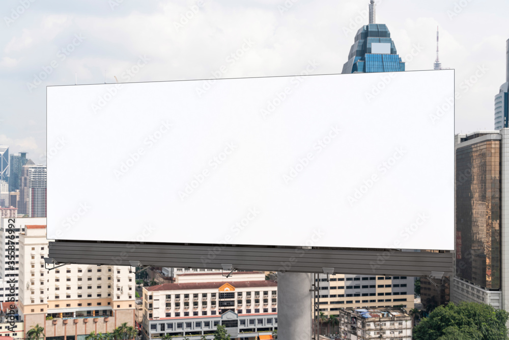 Fototapeta premium Blank white road billboard with KL cityscape background at day time. Street advertising poster, mock up, 3D rendering. Front view. The concept of marketing communication to promote or sell idea.