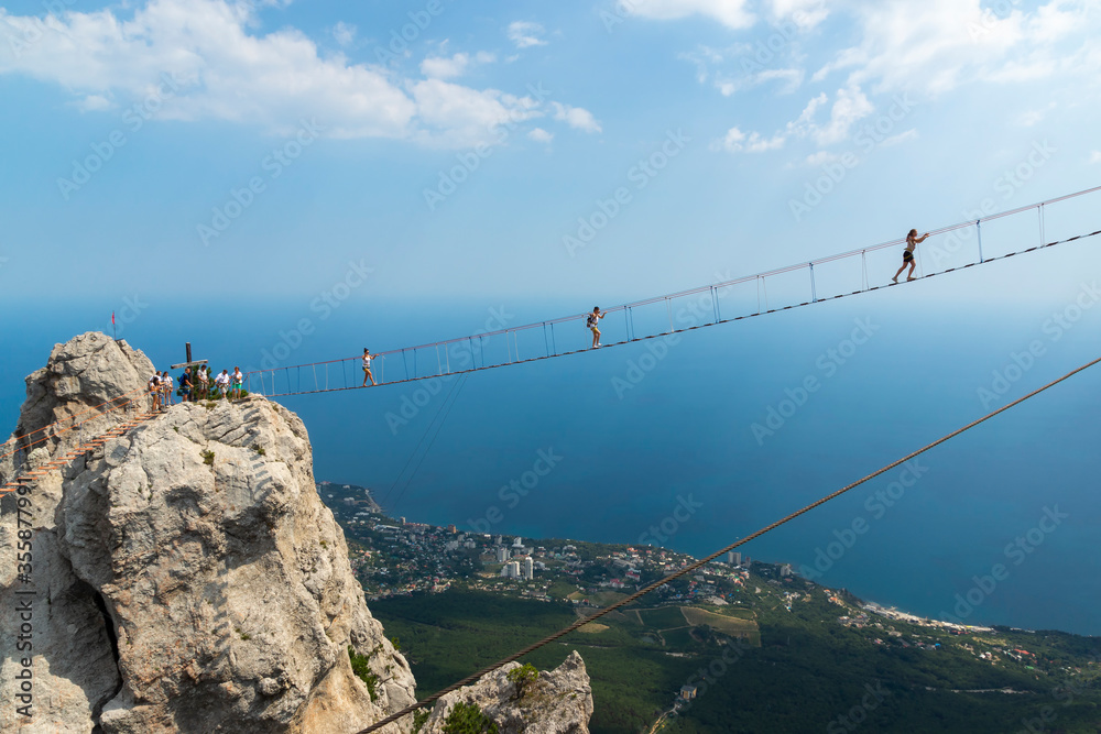 Suspension bridge on Mount Ai-Petri, Crimean Peninsula. Thrill attraction. Mountain peaks with sea view.