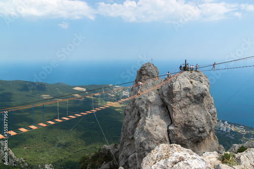 Obraz na płótnie Suspension bridge on Mount Ai-Petri, Crimean Peninsula. Thrill attraction. Mountain peaks with sea view. w salonie