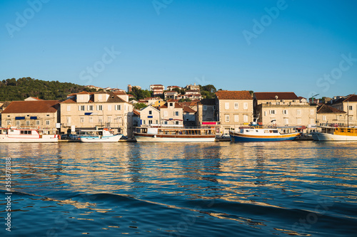 Fototapeta Naklejka Na Ścianę i Meble -  City by the sea in summer cityscape of Trogir town. Sunny morning seascape of Adriatic sea. Beautiful world of Mediterranean countries. Traveling concept background