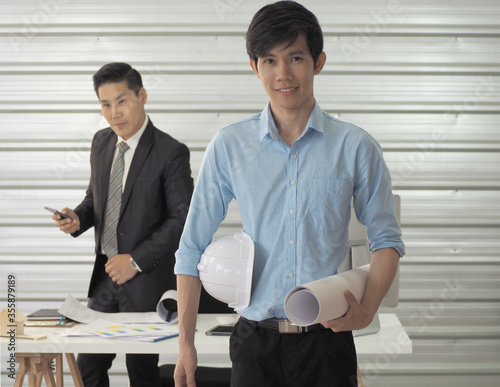  Architect or engineer or foreman hold blueprint and construction helmet is standing.