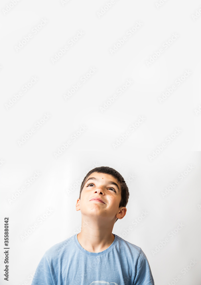 Boy looking up into a white blank background Boy looking up into a white blank background