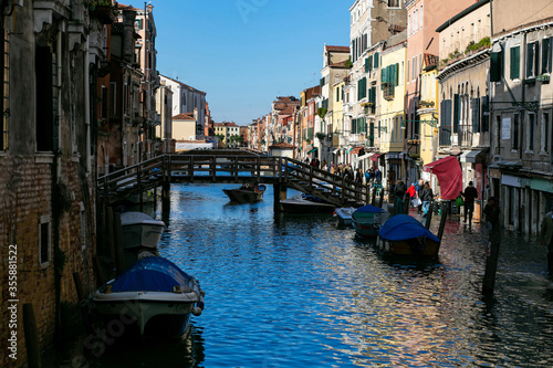 horizontal panoramic photo of a canal in Venice with many boats