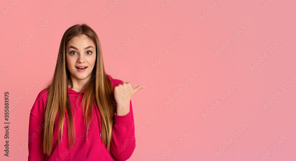 Surprise concept. Shocked girl points finger at empty space Surprise concept. Shocked girl points finger at empty space