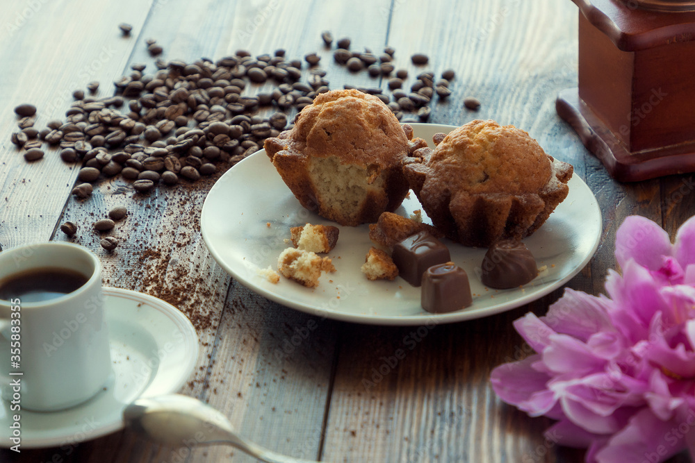 Coffee grinder and cup of coffee on brown wooden background with cakes. Breakfast concept Coffee grinder and cup of coffee on brown wooden background with cakes. Breakfast concept