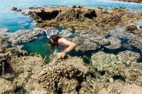 Man in the mask for posing against the backdrop of the beautiful sea landscape and corall reef photo