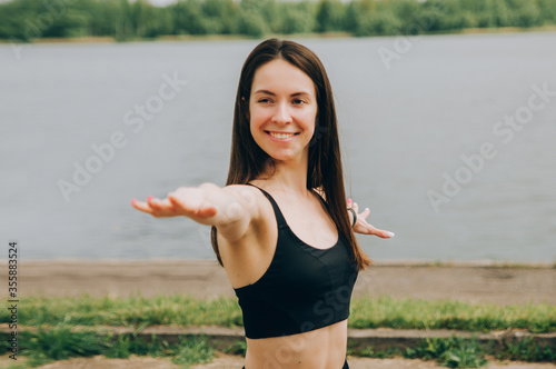 Beautiful fitness girl posing on blue wall background outdoors, copy space. Sporty woman with perfect body, healthy lifestyle and bodycare concept photo