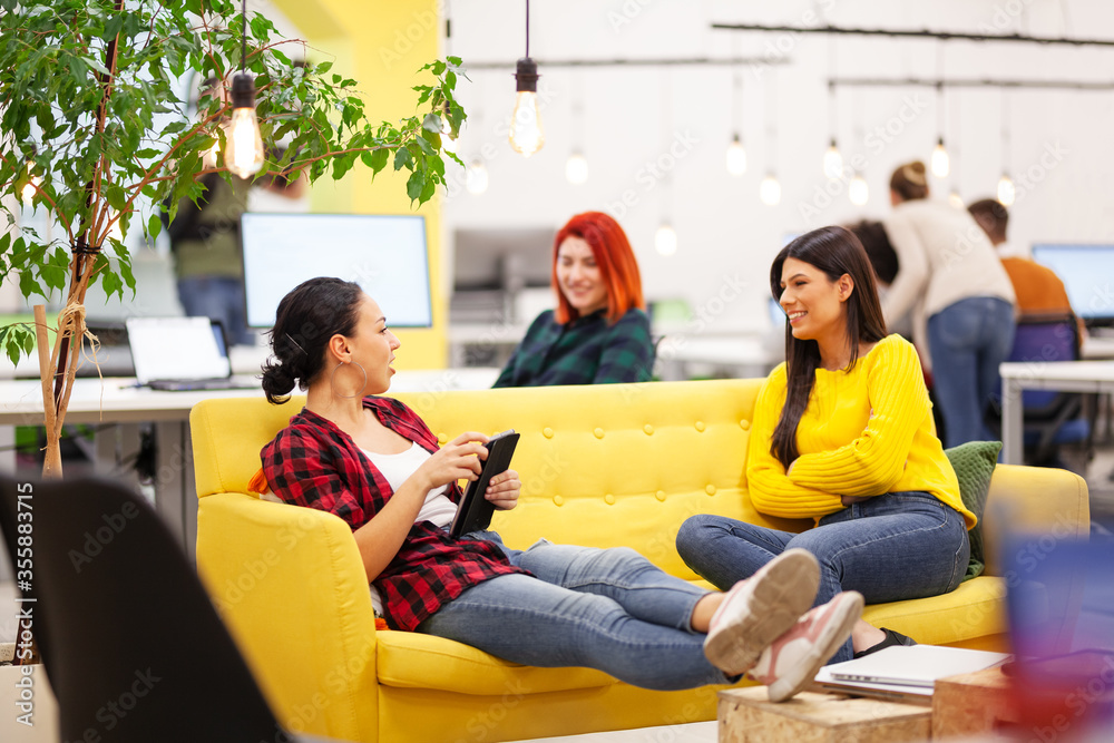 Three beautiful young female business colleagues having a chat in a modern office. Successfull startup team having a brainstorming meeting Three beautiful young female business colleagues having a chat in a modern office. Successfull startup team having a brainstorming meeting
