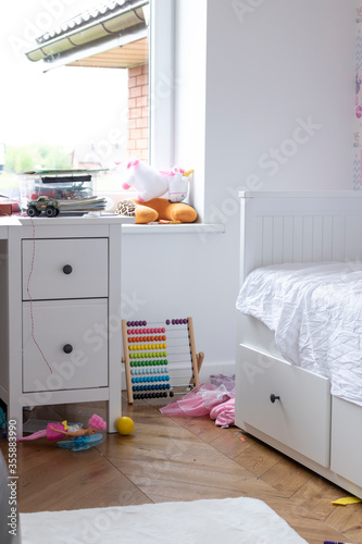 A messy girl's room full of disorder and toys.