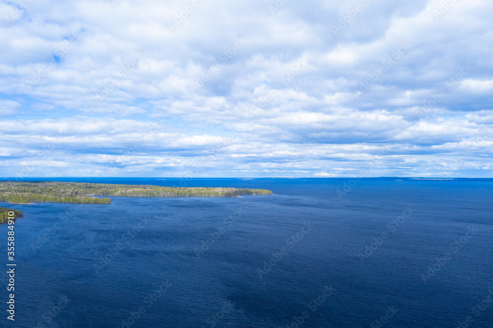 Aerial view summer forest and lake. Top view. Coastline view from drone. Aerial top view cloudscape. Texture of clouds. View from above. Top view water surface