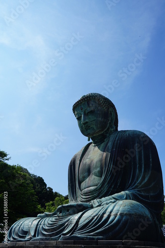 The Great Buddha of Kamakura is an outdoor bronze statue of Amida Buddha under blue sky located on the grounds of Kotoku-in Temple in Kanagawa Prefecture Japan. Kamakura Daibutsu Statue. photo