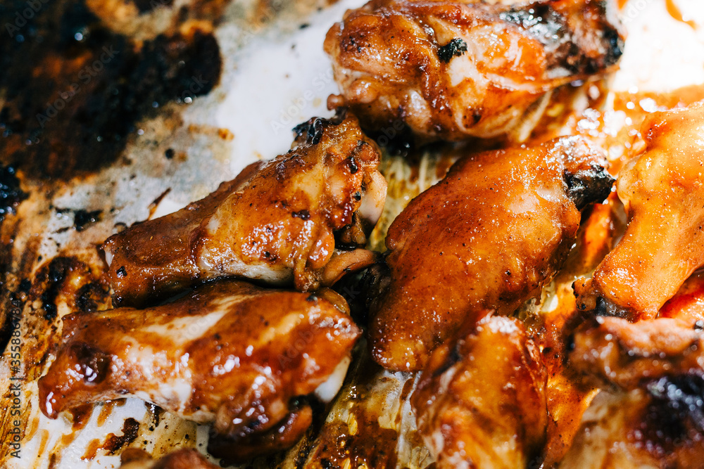 Delicious and Sticky Glazed Barbecue Chicken Wings on a Baking Tray. 