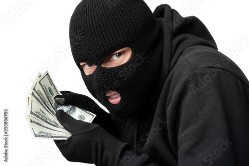 Masked thief counting money isolated over white wall photo