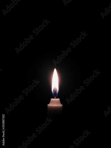 burning candle on black background