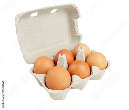 A carton pack of six brown chicken eggs isolated on white background.