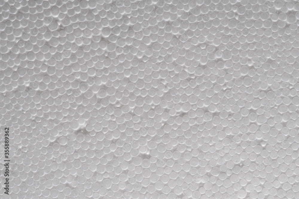 Uneven texture of plastic foam . White styrofoam board. Closeup. Polystyrene sheet surface. Abstract circles background