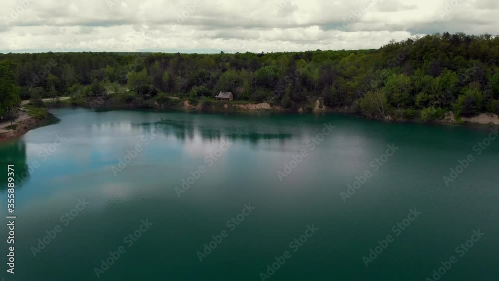Aerial Top Down View, Flooded quarry with turquoise clear water and green forest around. Beautiful landscape with forest and lake. Lake with turquoise water and green trees. Crystal clear water Aerial Top Down View, Flooded quarry with turquoise clear water and green forest around. Beautiful landscape with forest and lake. Lake with turquoise water and green trees. Crystal clear water