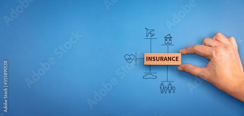 hand holding a wooden block with text insurance, different type of insurance icons. Insurance  concept, different type of insurance background.