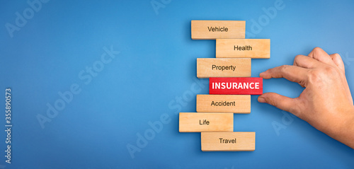 hand holding a wooden block with text insurance, different types of insurance text on wooden block. Insurance  concept, different type of insurance background.