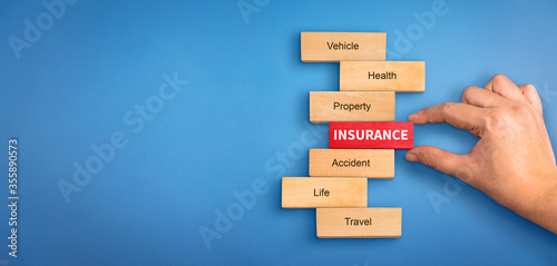 Obraz na plátně hand holding a wooden block with text insurance, different types of insurance text on wooden block
