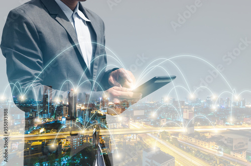 Valokuva double exposure business man using smartphone with city background wireless global internet web network connectivity technology digital connect futuristic concept