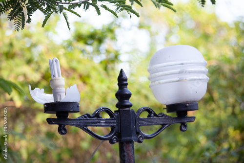 Broken lamps with unbroken stands in the park.