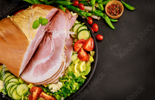 Whole cutted ham with vegetables and herbs.
