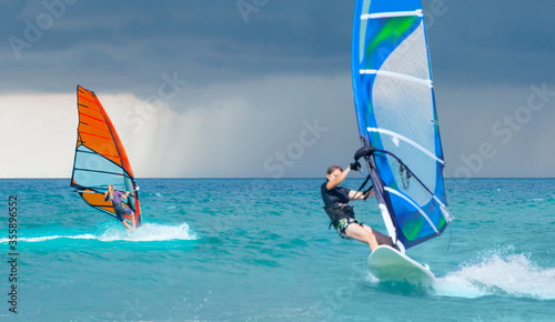 Beautiful cloudy sky with (same) Windsurfer Surfing The Wind On Waves In Alacati - Cesme, Turkey 