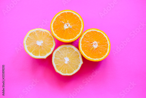 sliced oranges and lemons are laying on the plain backgrounds, colourful fruit, fresh citrus
