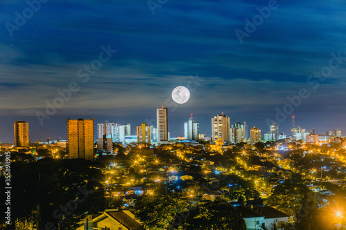 Paisagem noturna de Apucarana, município no Paraná, sul do Brasil. Prédios iluminados pela lua cheia photo