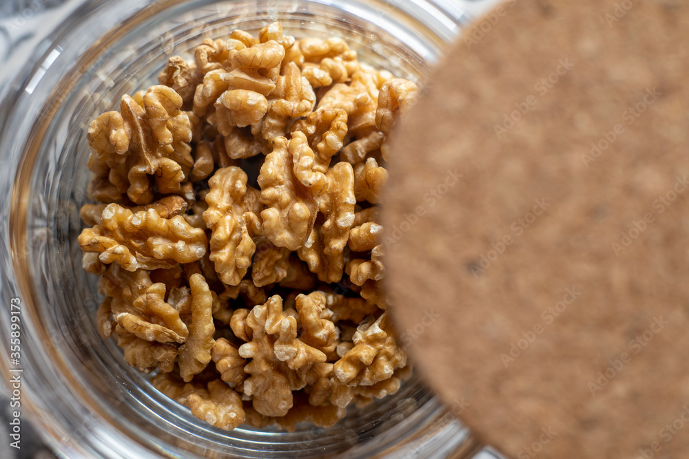 Close up of healthy organic bio walnuts inside a glass jar with a cork cover Close up of healthy organic bio walnuts inside a glass jar with a cork cover