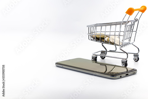 close up shopping cart coin smartphone white background concept e-commerce © atitaph