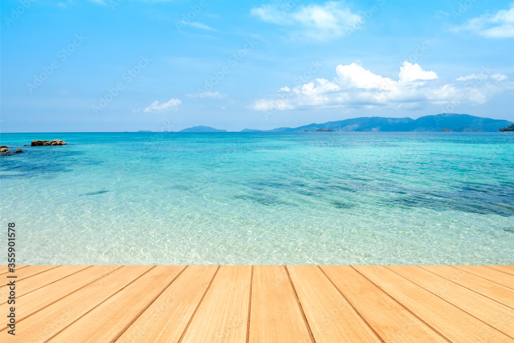 Fototapeta premium Empty wooden board table top with blurred beautiful blue or turquoise Ocean and beautiful blue sky.