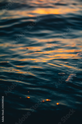 The colorful surface of the yellow and blue waters with ripples on the sea. Sea surface at dawn.
