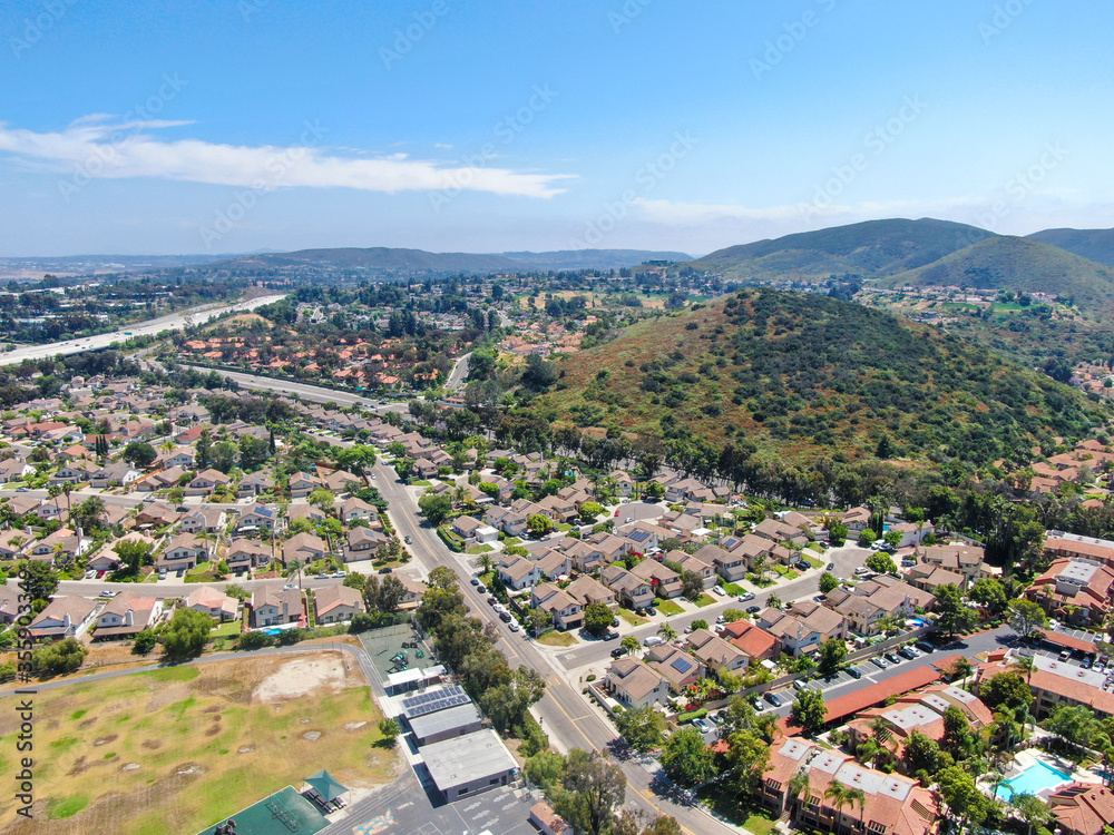Aerial view middle class neighborhood with condo community and residential house and mountain on the background in Rancho Bernardo, South California, USA.