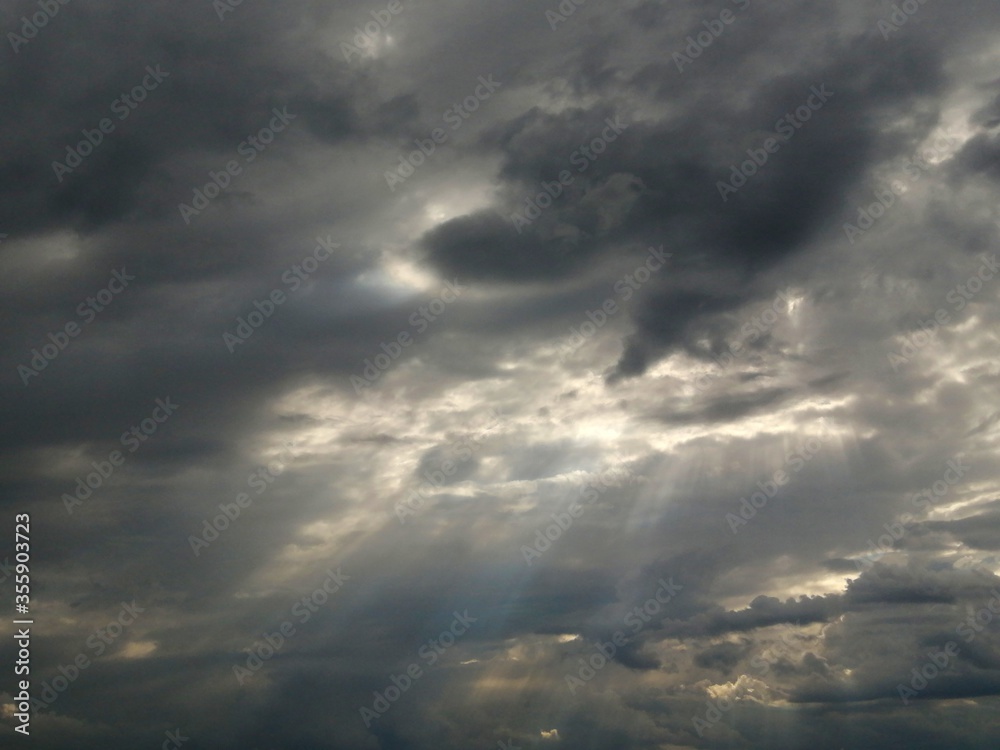 Dark sky with clouds. Rays of the sun through dark clouds.