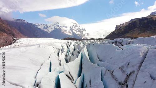 Aerial drone flight over the ice surface of the Svinafellsjokull glacier, Vatnajokull National Park in Iceland, with the mountains in the background photo