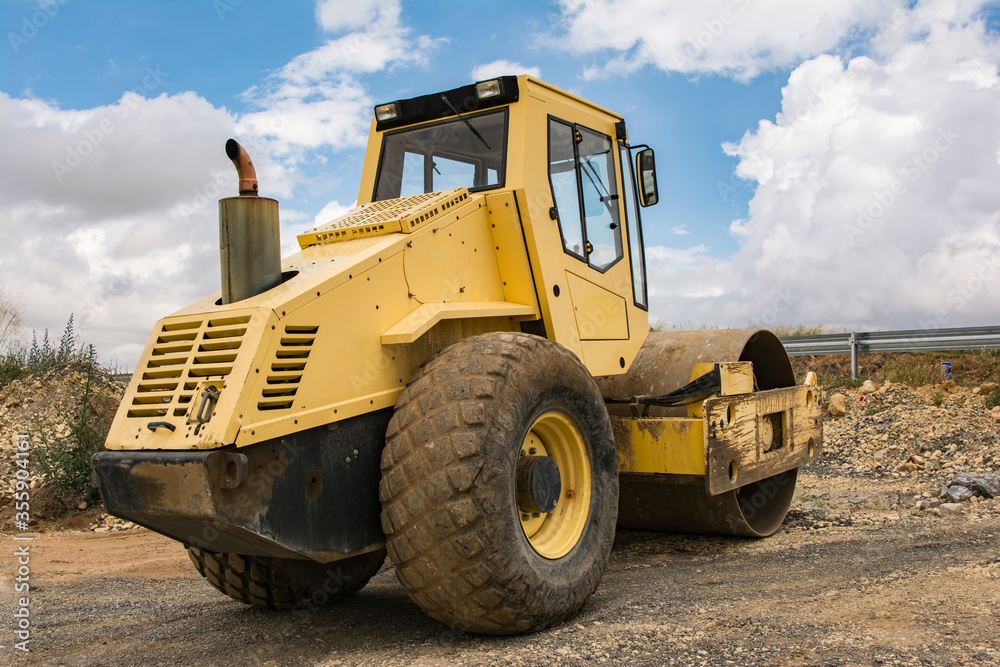 Yellow steamroller doing road construction work Yellow steamroller doing road construction work