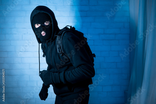 Sneaky robber ready to steal something at home