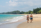 Couple holding hands walking at white sand at tropical beach in Phuket island,Thailand