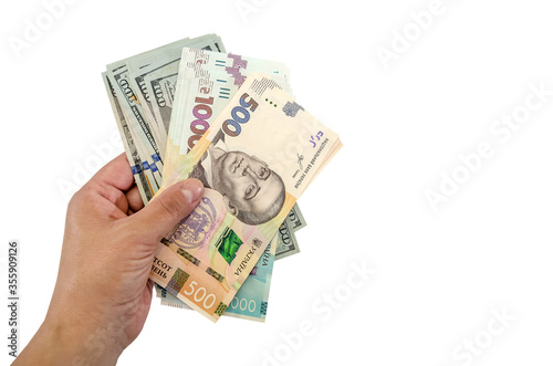 Ukrainian hryvnia and dollars in hand isolated on a white background. Copy of space.