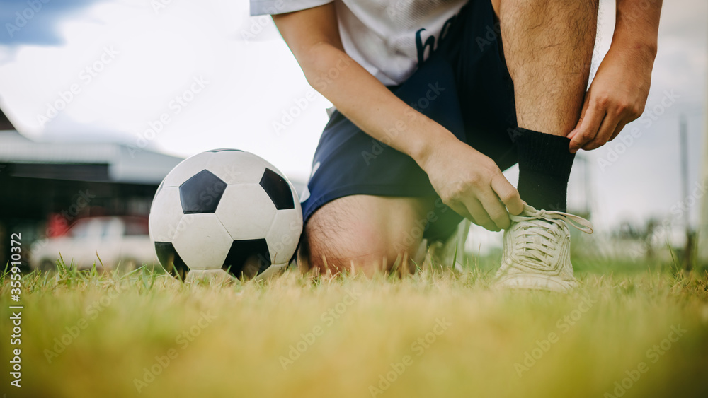 Αυτοκόλλητο Action sport outdoors of soccer ball player playing football for exercise in community rural area under the twilight sunset