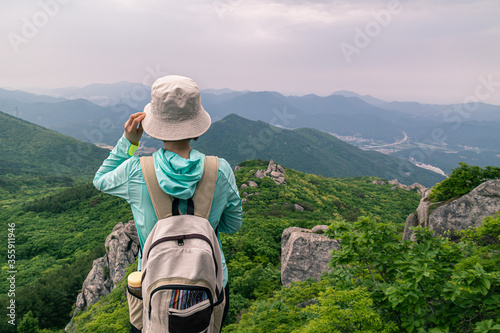 a woman who see natural scenery at the top of a high Geumjeongsan mountain in Busan, South Korea. photo