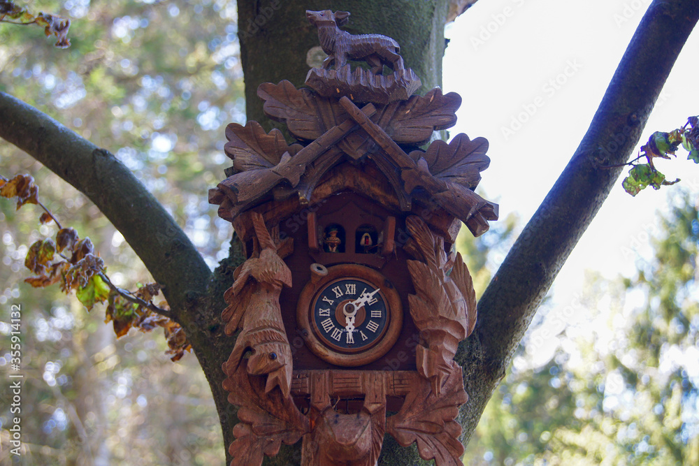 Handcrafted wooden cuckoo clock mounted on a tree truck in the Black ...