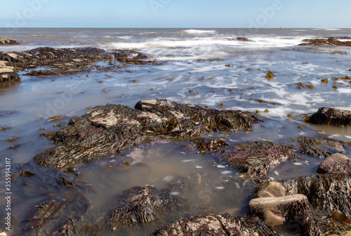 Rocky beach water waves with slow shutter motion blur