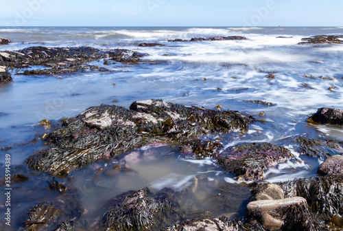 Rocky beach water waves with slow shutter motion blur